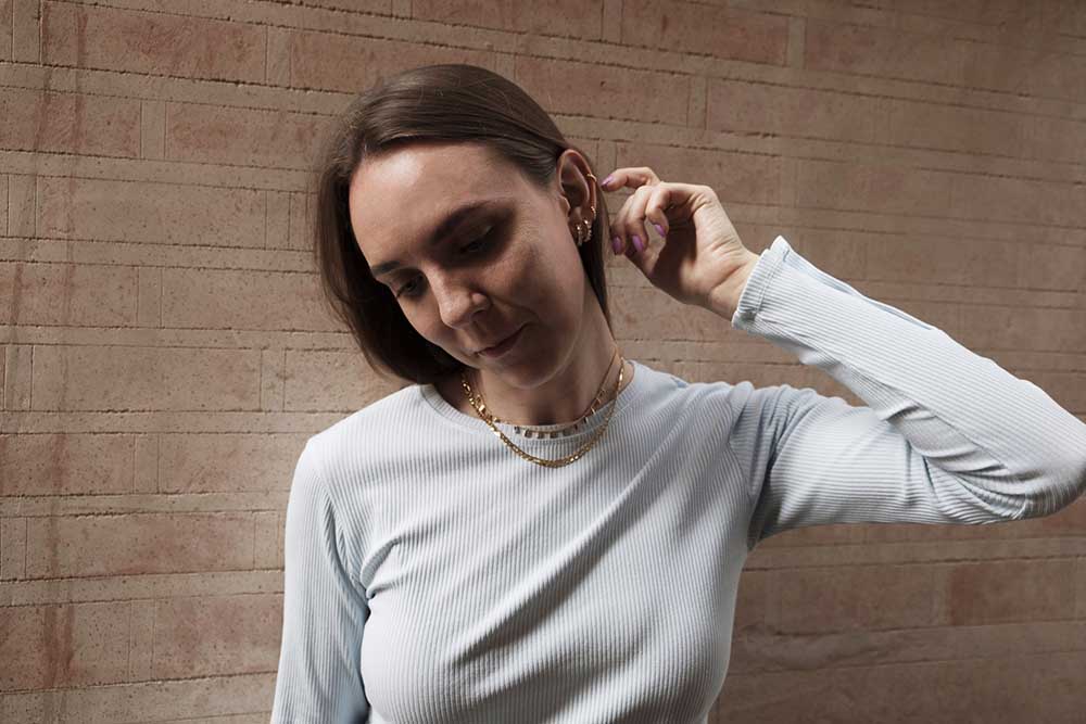 Mujer joven. Sus orejas y manos están adornadas con joyas de plata.